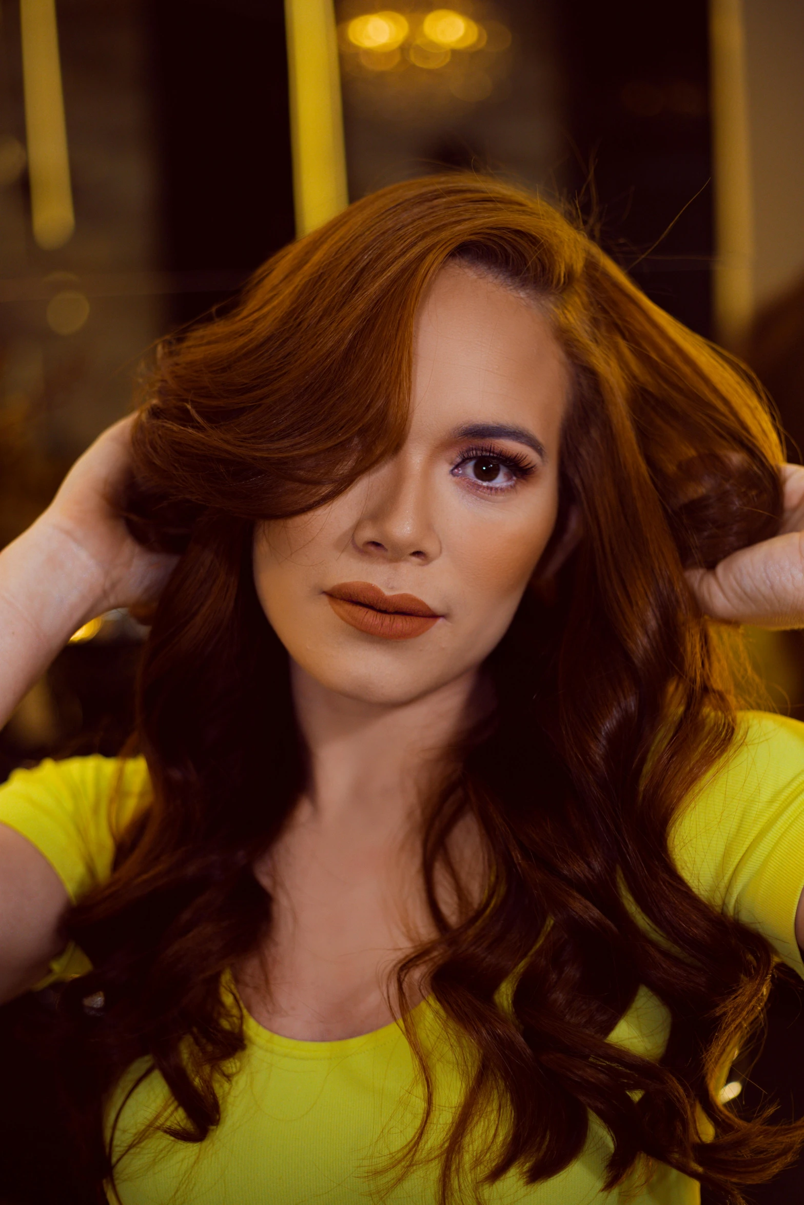 a woman in a yellow shirt combing her hair, an album cover, inspired by Jorge Jacinto, pexels contest winner, auburn hair, looking defiantly at the camera, glam hair, mai anh tran