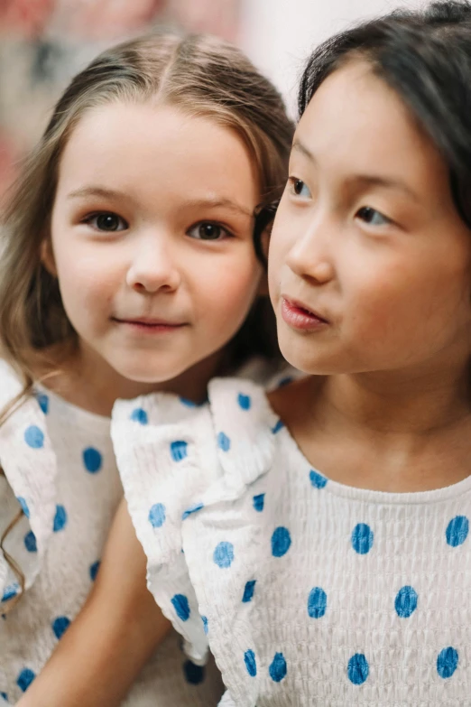 a couple of young girls sitting next to each other, unsplash, process art, polka dot, blue soft details, closeup of an adorable, patterned clothing