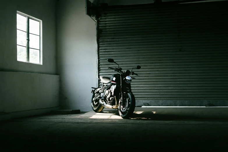 a motorcycle is parked by the window in a darkened room