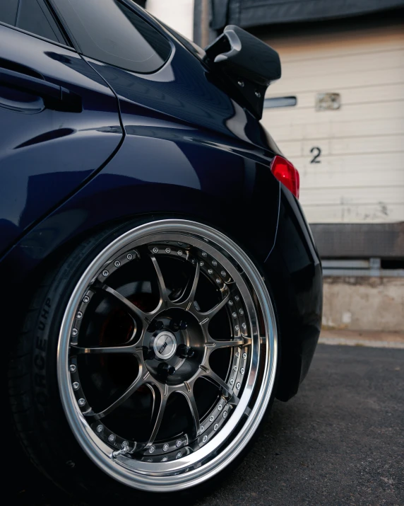 a car parked in front of a garage, inspired by An Gyeon, unsplash, detailed alloy wheels, close-up shot from behind, thumbnail, japanese drift car