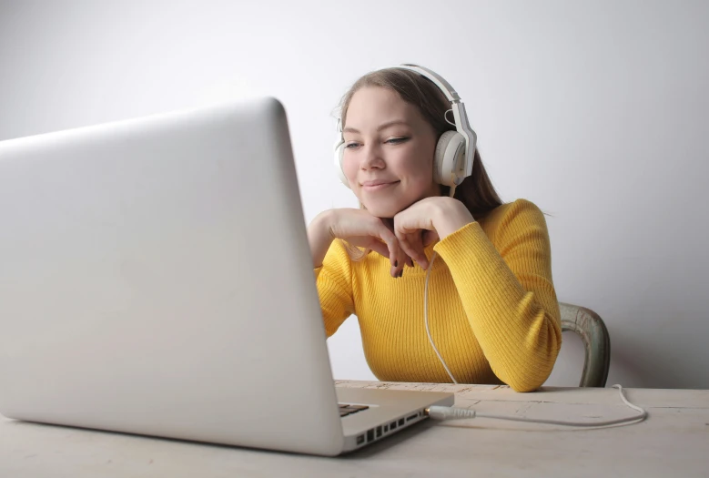 a woman sitting in front of a laptop wearing headphones, yellow theme, college, premium, instagram picture