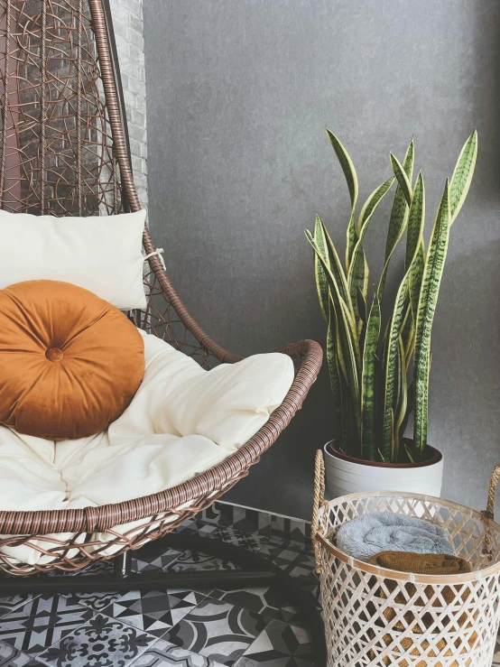 a hammock chair with pillows, plant and pot