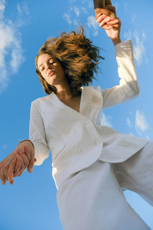 a woman flying through the air holding a tennis racquet, an album cover, unsplash, arabesque, wearing white suit, blue skies, portrait of barbara palvin, wearing a linen shirt