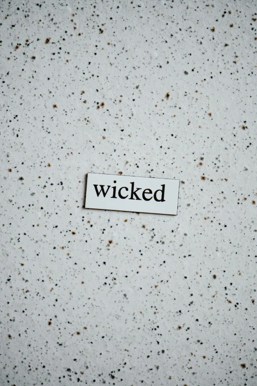 a piece of paper with the word wicked on it, an album cover, inspired by Ignacy Witkiewicz, trending on pexels, polished concrete, creepy aesthetic, speckled, single