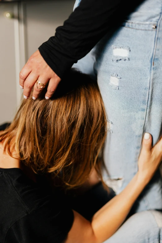 a woman with her back turned standing by another person