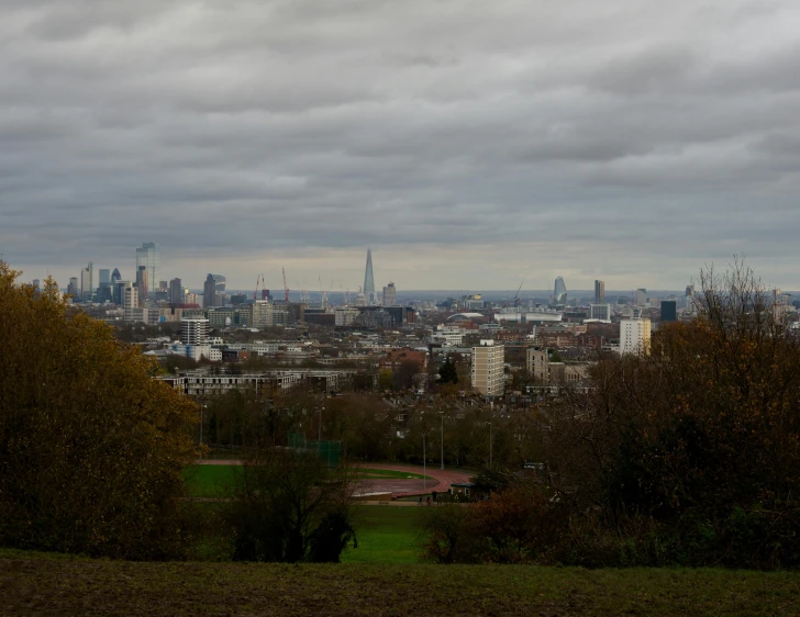 a view of a city from the top of a hill, london cemetery, slight overcast weather, cinematic shot ar 9:16 -n 6 -g, low quality photo