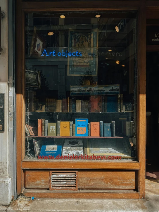 a shelf containing books, lit up and on the sidewalk