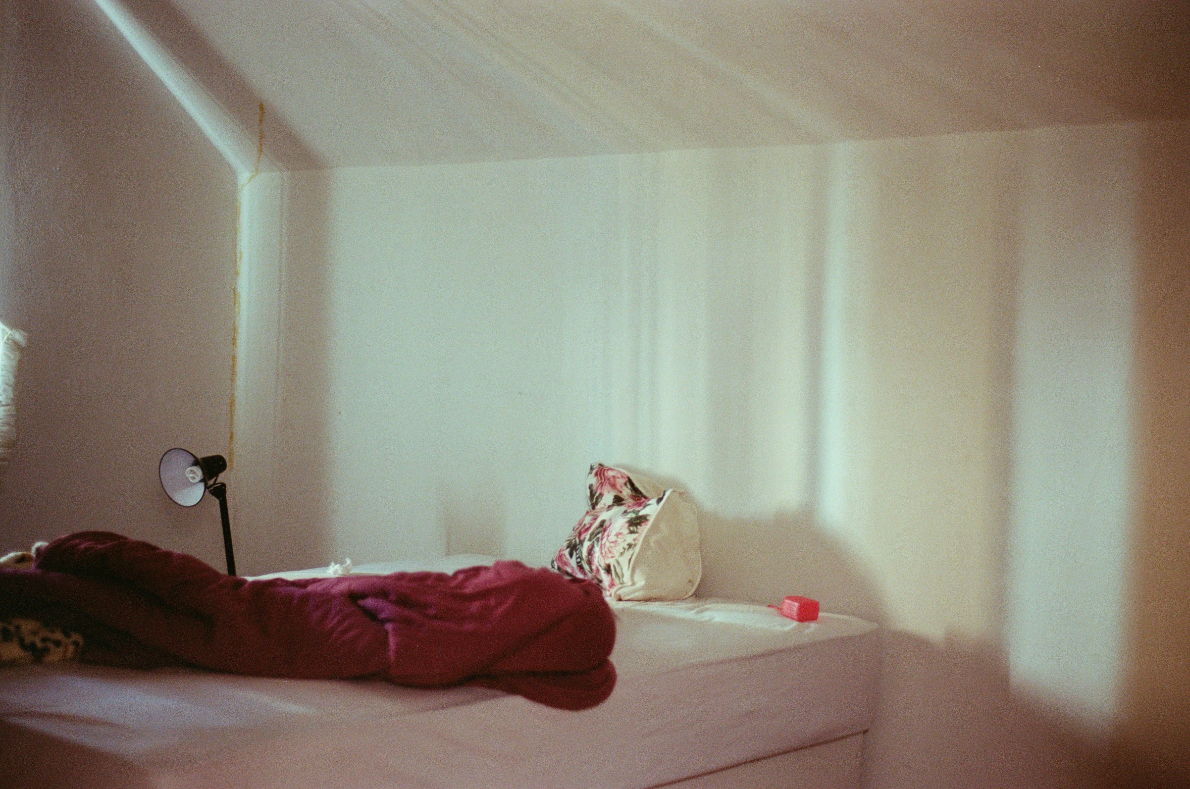 a bed in a room with a fan and wall light