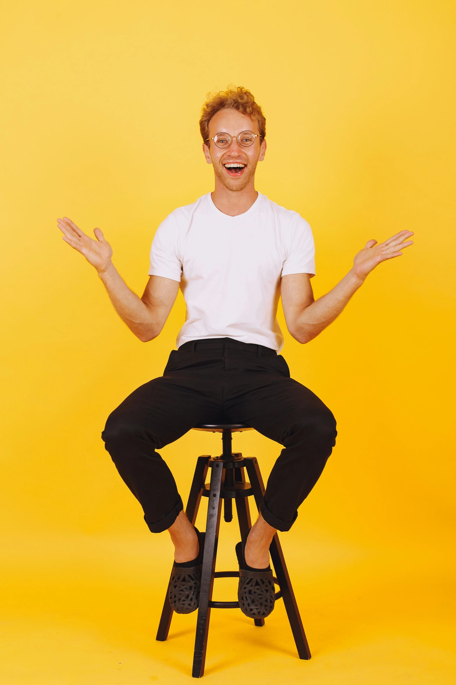 a man sits in a chair and holds his hands out