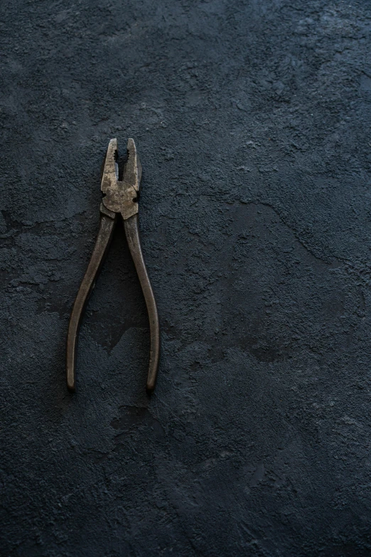 a pair of rusted and open wrenches on dark background