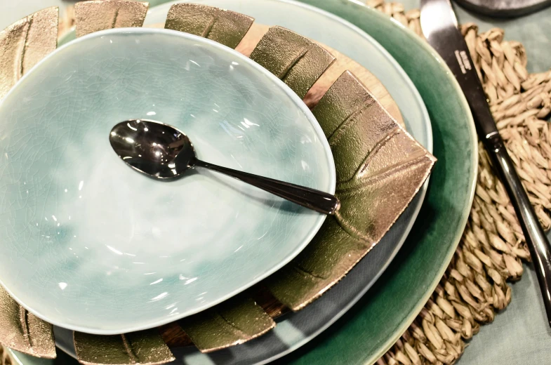 a close up of a plate with a spoon on it, inspired by Lewis Henry Meakin, hurufiyya, large leaves, glistening seafoam, place setting, multiple layers