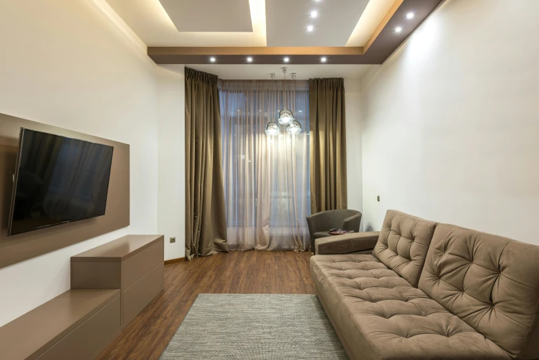 an empty living room with a couch, table and television on the wall