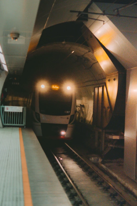 a subway train pulling into a station next to a platform, late 2000’s, under light, transmetal ii, in sao paulo