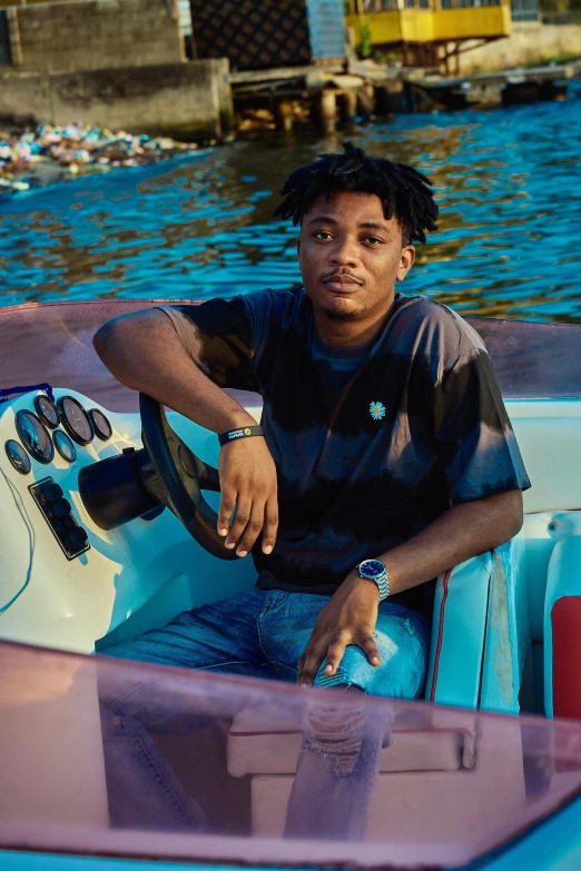 a young man driving a small boat on the water