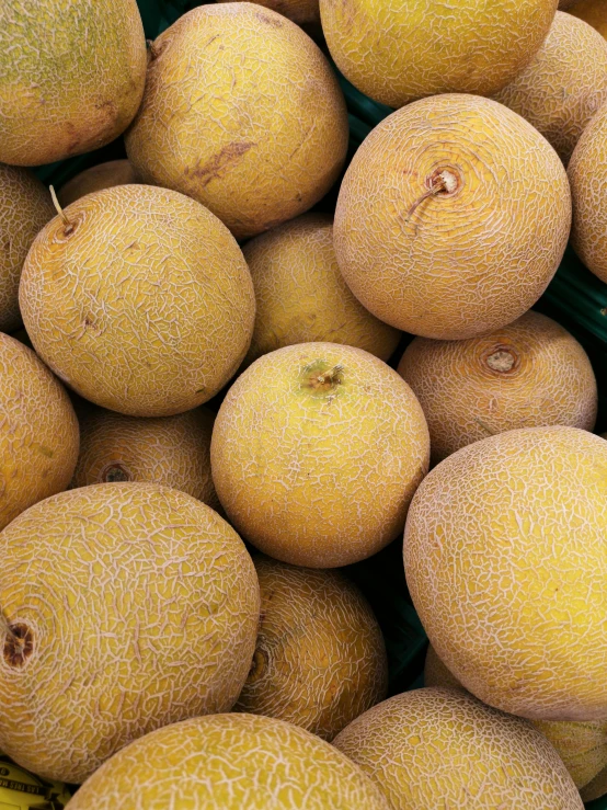 yellow, round fruits are piled up in bowls