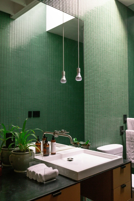 a very green bathroom with towel racks hanging