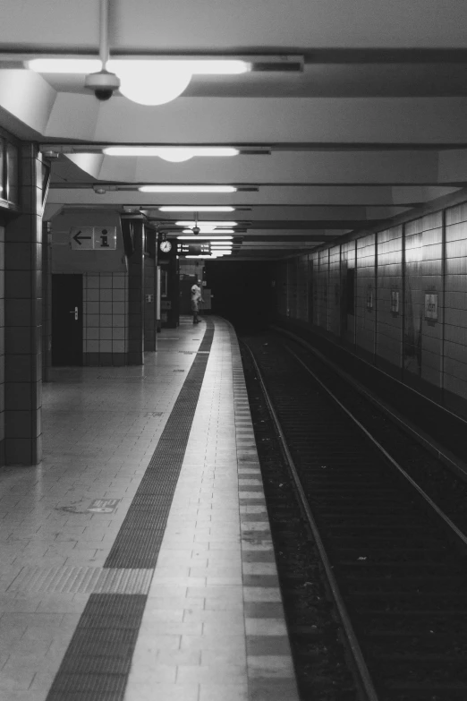 a black and white photo of a subway station, a black and white photo, unsplash, postminimalism, berlin 1 9 8 2, square lines, lonely astronaut, early evening