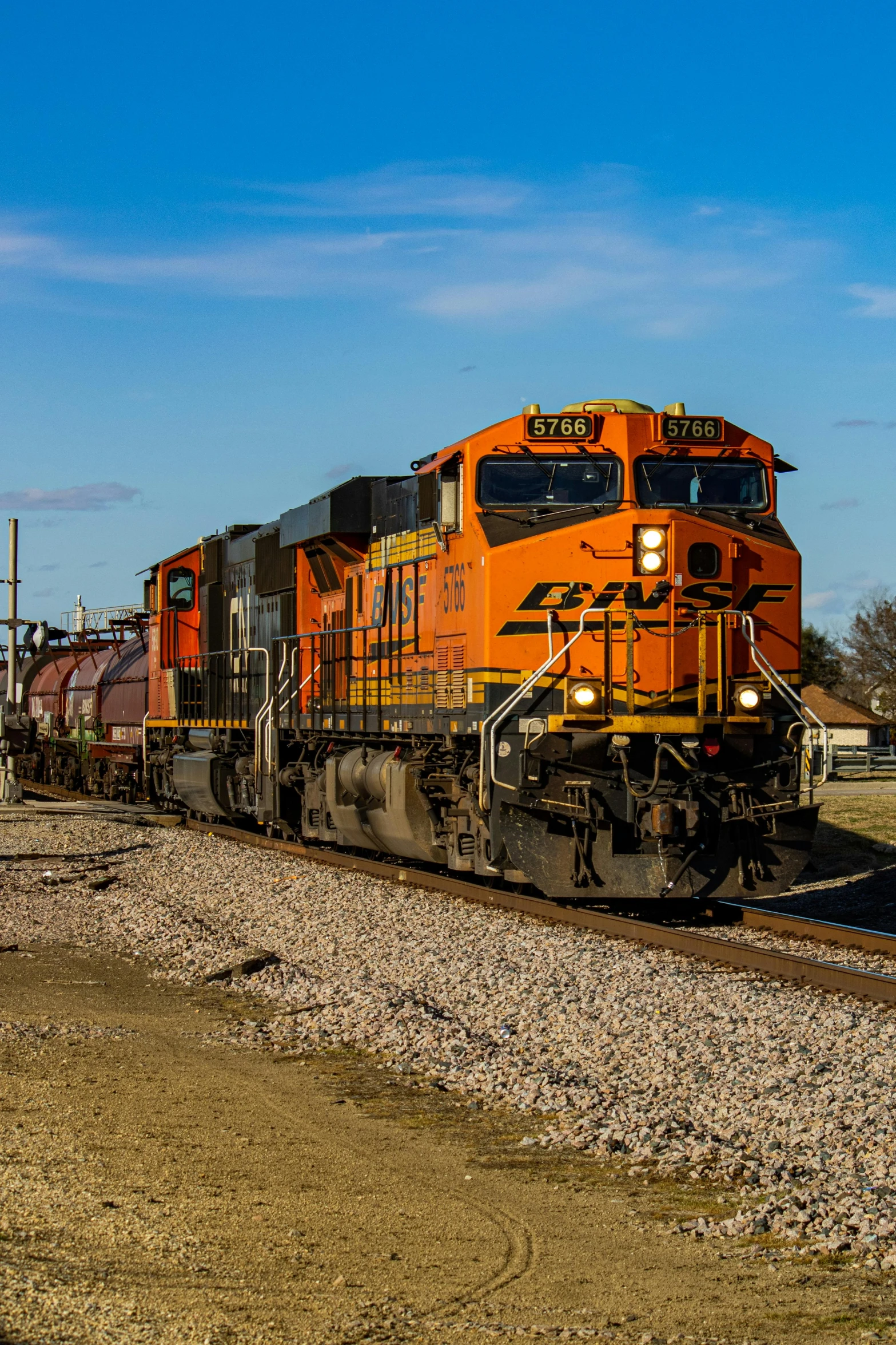 a large long train on a steel track, a portrait, by Arnie Swekel, unsplash, orange and black, square, springtime morning, diesel engine