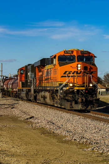 a large long train on a steel track, a portrait, by Arnie Swekel, unsplash, orange and black, square, springtime morning, diesel engine