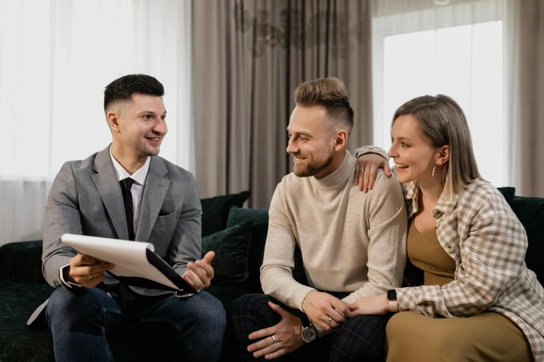 three people sitting on a couch looking at a tablet, by Adam Marczyński, pexels contest winner, selling insurance, with anchor man and woman, smiling couple, artem chebokha