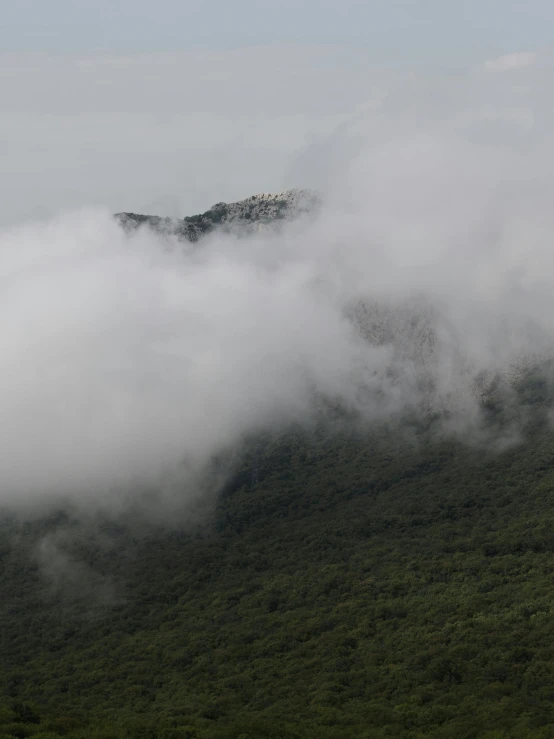 mountains covered in clouds and a hazy sky