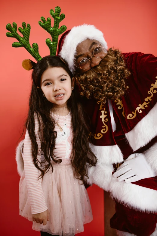 an old man and girl with a christmas outfit