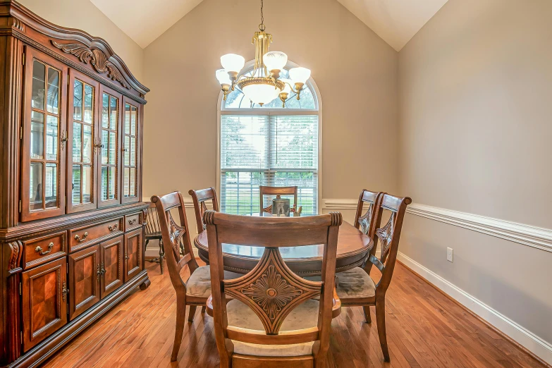 a wooden table with chairs underneath a fancy chandelier