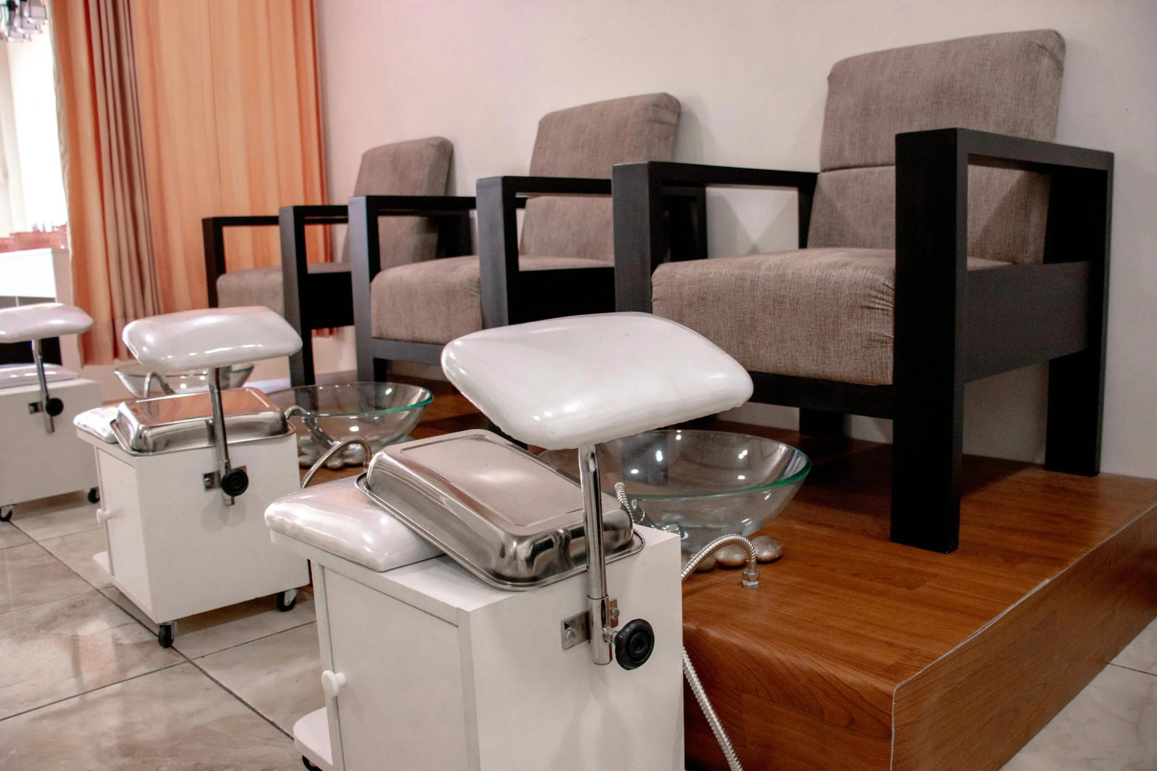 a white salon chair with some beige chairs and glass shelves in the room