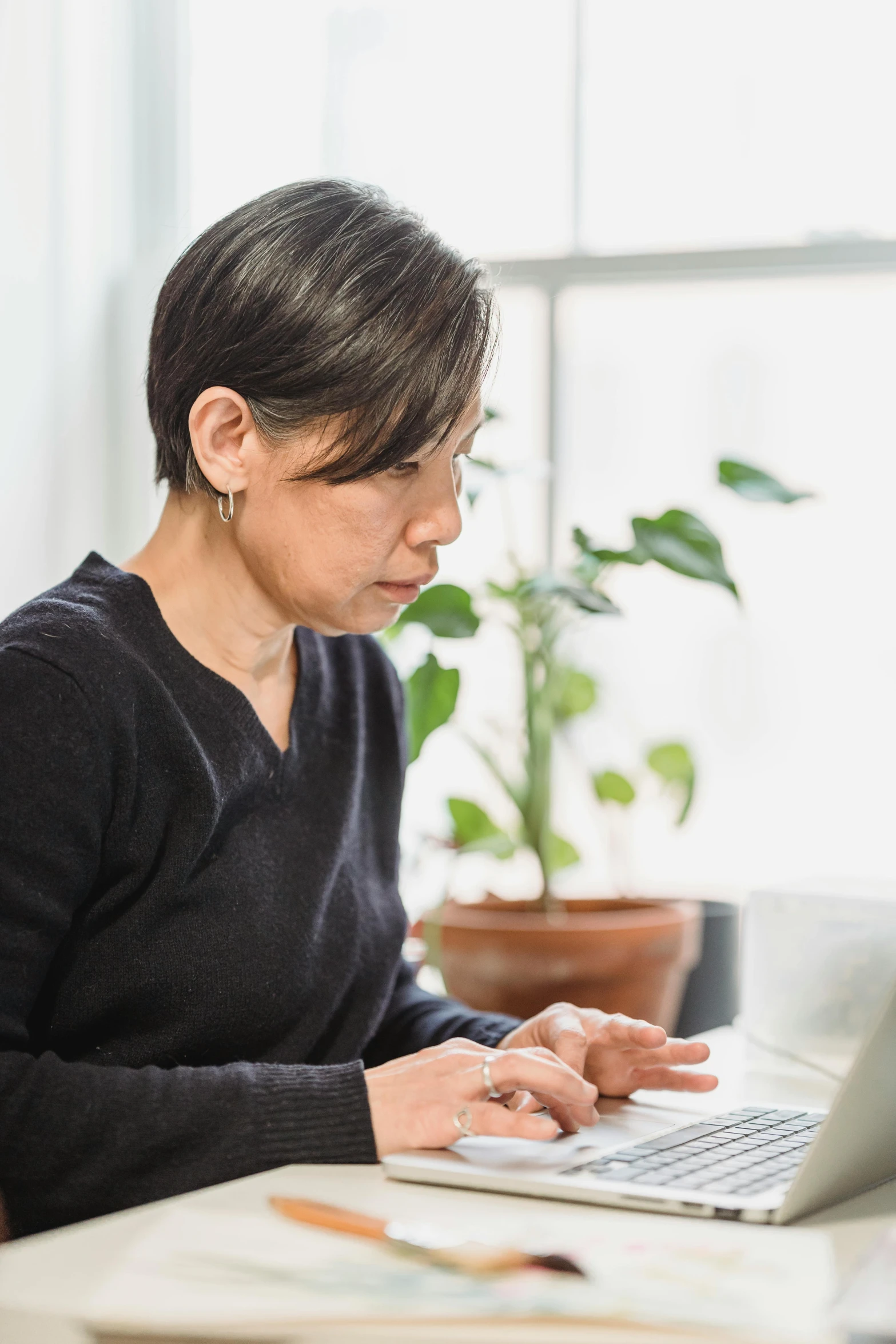 a woman sitting at a desk using a laptop computer, inspired by Li Di, unsplash, ethnicity : japanese, profile image, no cropping, 40 years old women