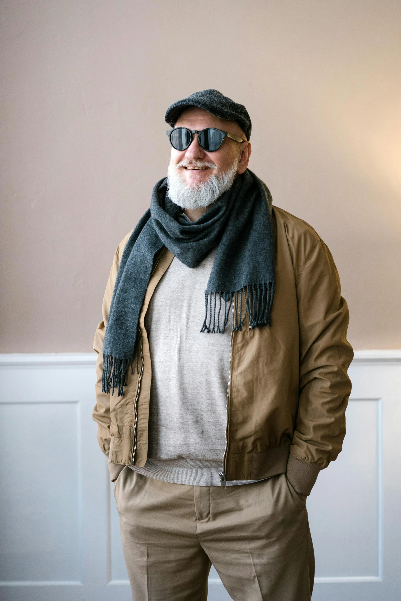 a man standing in a room wearing a hat and scarf, inspired by Agnolo Gaddi, unsplash, photorealism, beret and sunglasses, greybeard, casual clothing, colin hay