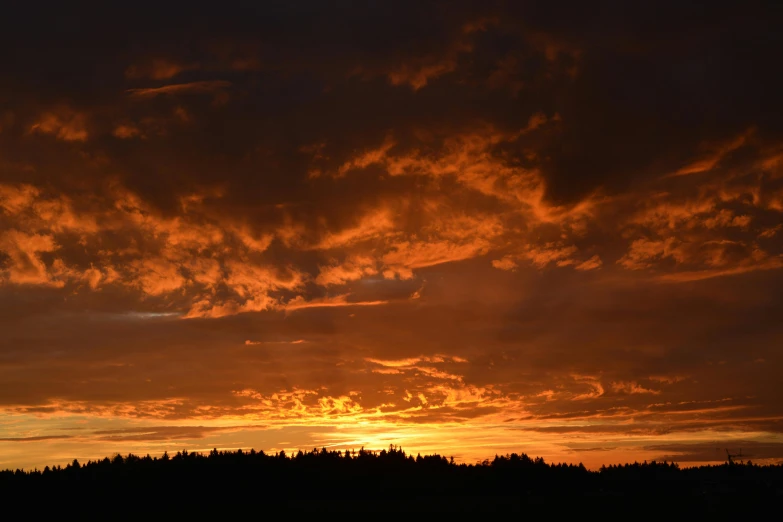 a large body of water with a sunset in the background, the sky is red, forest fires in the distance, today\'s featured photograph 4k, ceremonial clouds