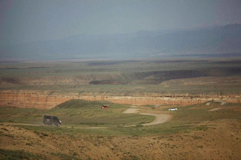 a jeep on a dirt road in the middle of the field