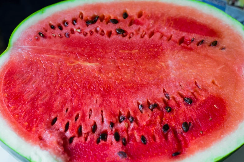 a slice of watermelon sitting on top of a table, a macro photograph, pexels, hurufiyya, heat wave, 2000s photo, 3 4 5 3 1, conor walton