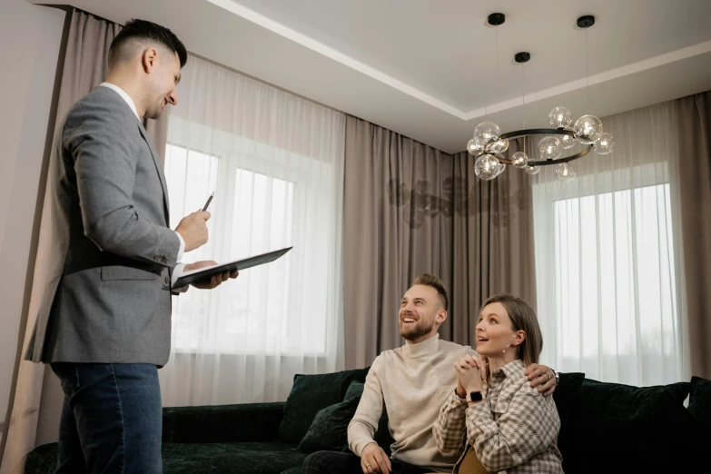 a man standing next to a woman in a living room, pexels contest winner, selling insurance, brown, thumbnail, 15081959 21121991 01012000 4k