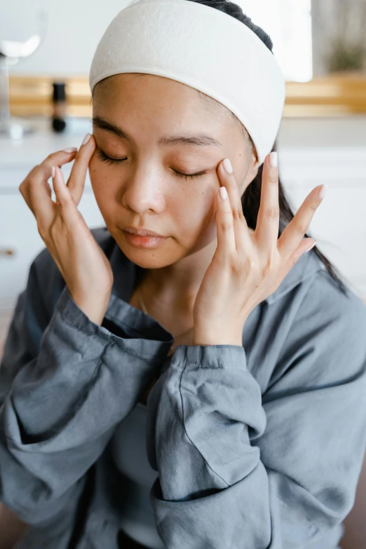 a woman sitting on a couch with her eyes closed, trending on pexels, renaissance, japanese facial features, hands on counter, turban, cysts