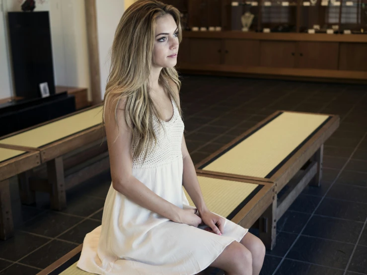 a woman in a white dress sitting on a bench, health spa and meditation center, sydney sweeney, indoor picture, modelling