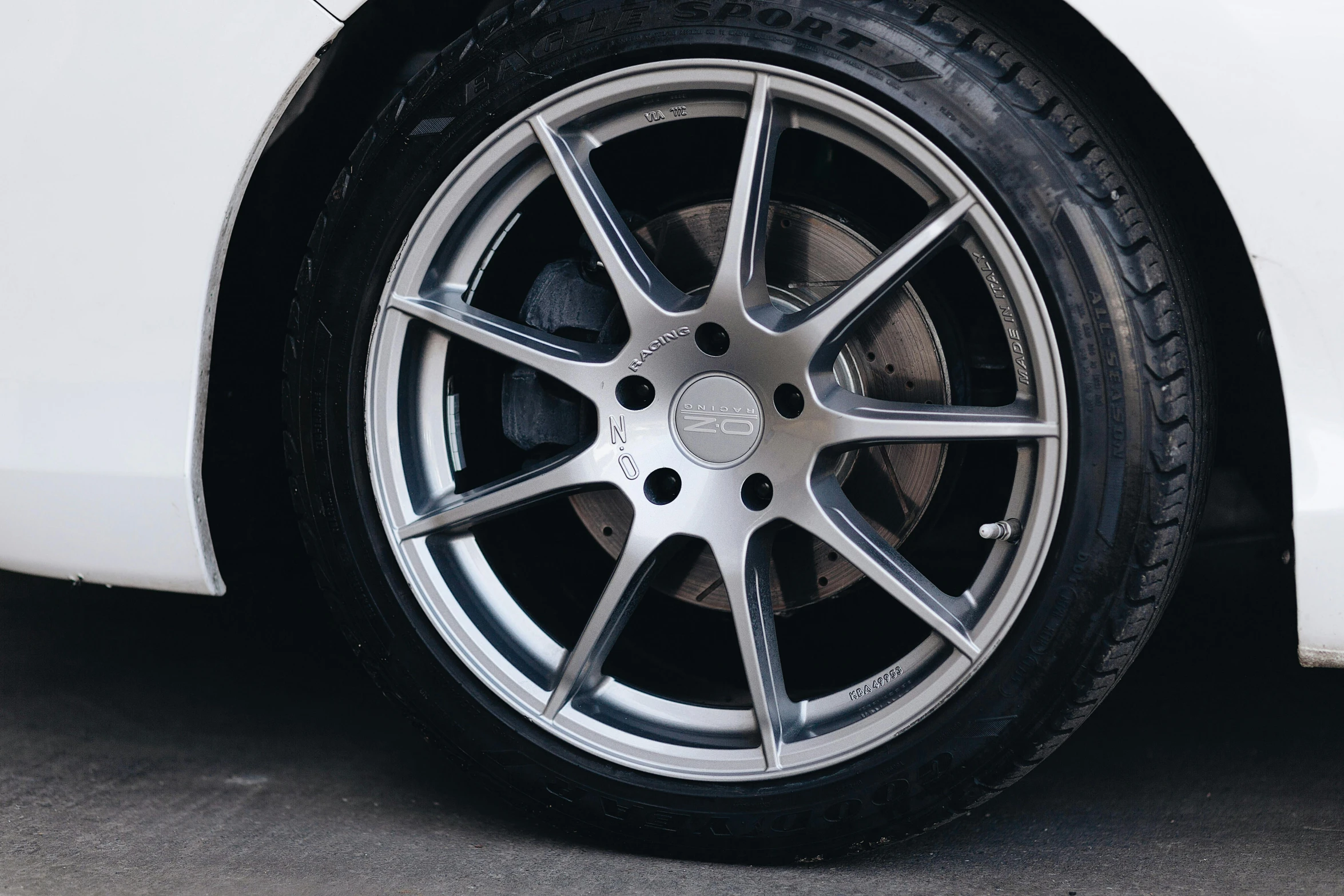 a close up of a tire on a white car, pexels contest winner, grey and silver, instagram post, cart wheels, medium height