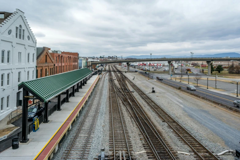 a train station with a train on the tracks, by Carey Morris, unsplash, ai weiwei and gregory crewdson, wide high angle view, chesterfield, cityscape