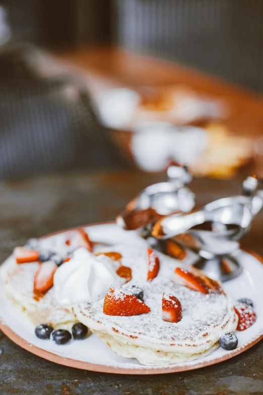 some pancakes are covered with berries on a plate