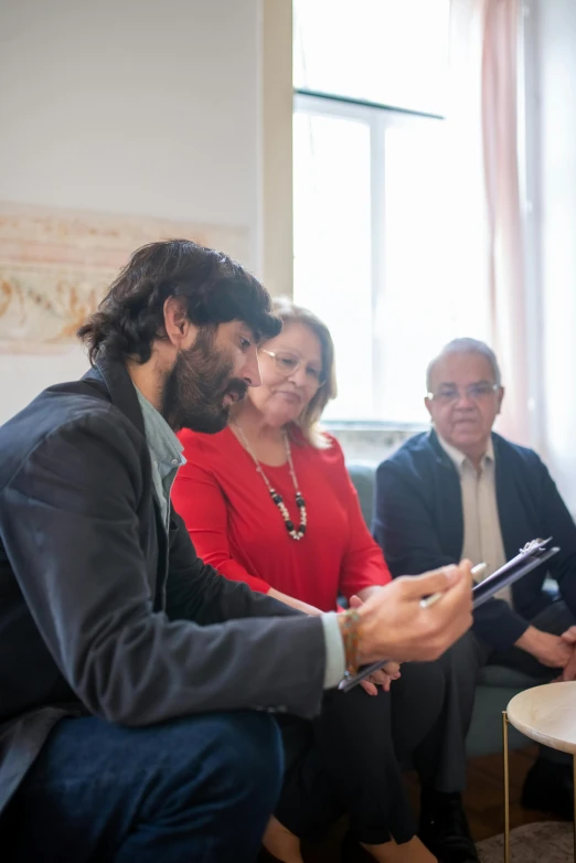 a group of people sitting on a couch in a living room, by Giuseppe Avanzi, signing a bill, in a meeting room, promo image, mantegna