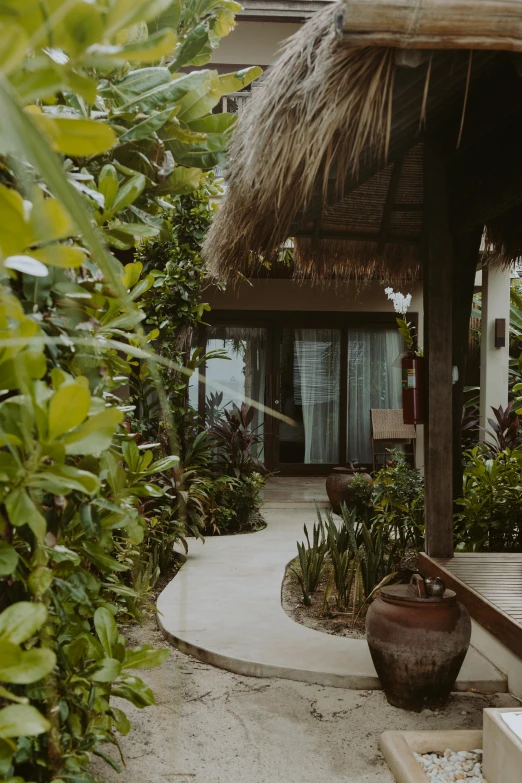 a lush green outdoor area with a grass roof and thatched gazebo