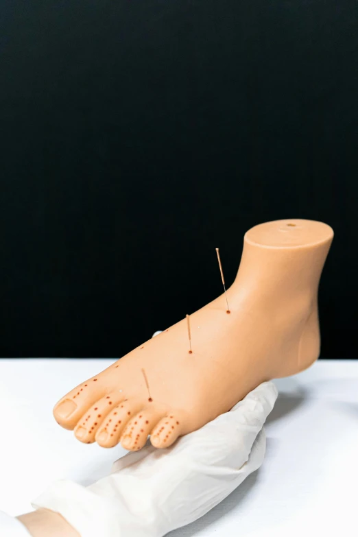 a close up of a person's foot on a table, figuration libre, needles, display item, artificial, foam