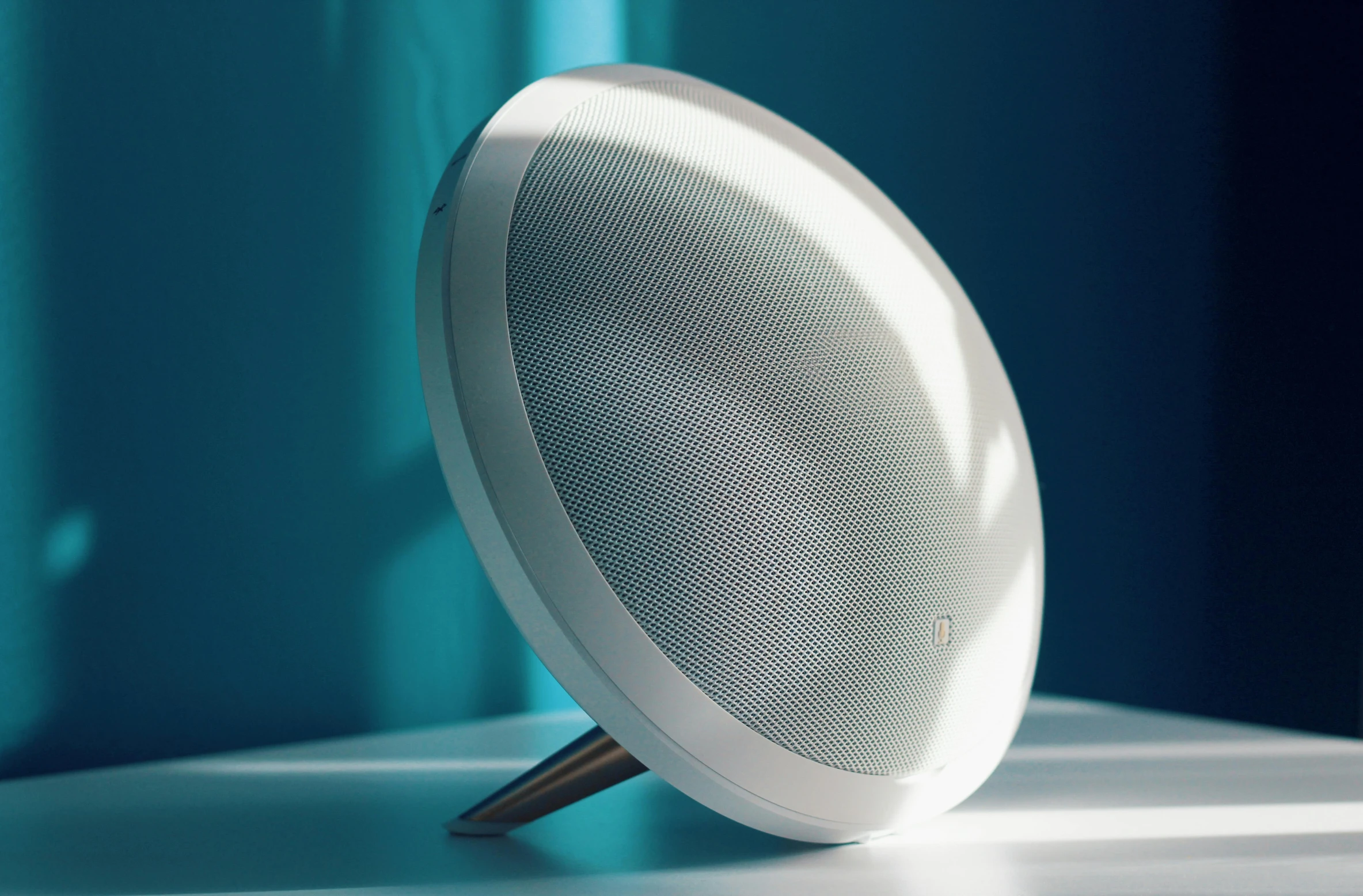 a white speaker sitting on top of a table, inspired by Carl Gustaf Pilo, unsplash, ambient teal light, halo array, magnificent oval face, renaissance nimbus overhead