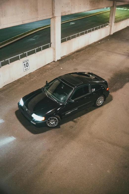 a parked black car sitting inside a building