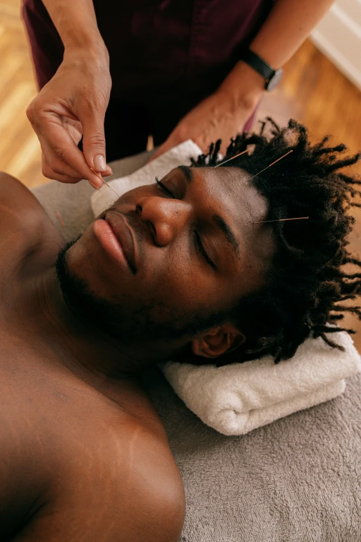 a man with dreads doing a haircut on his forehead