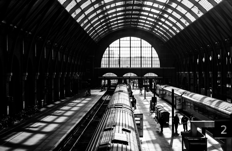 a black and white photo of a train station, inspired by Alfred Eisenstaedt, pexels contest winner, london architecture, bright daylight indoor photo, silhouette!!!, anna nikonova