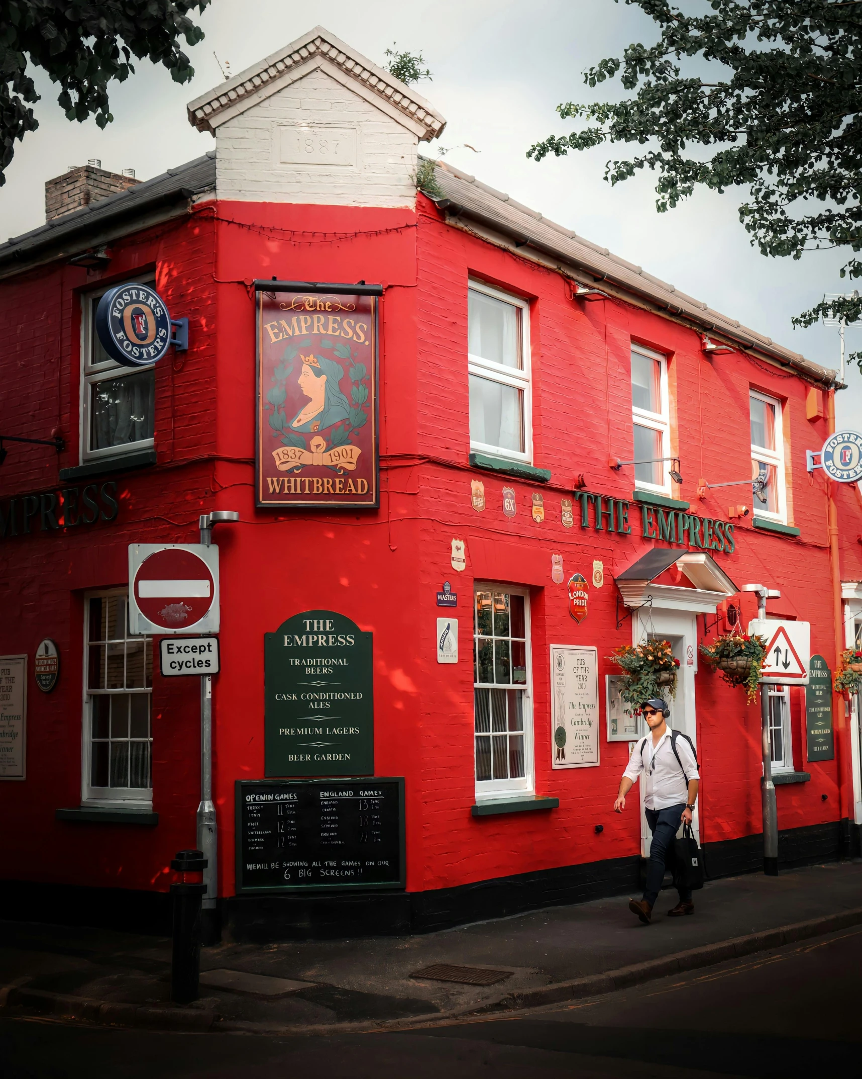 a person walking past a red building near the street