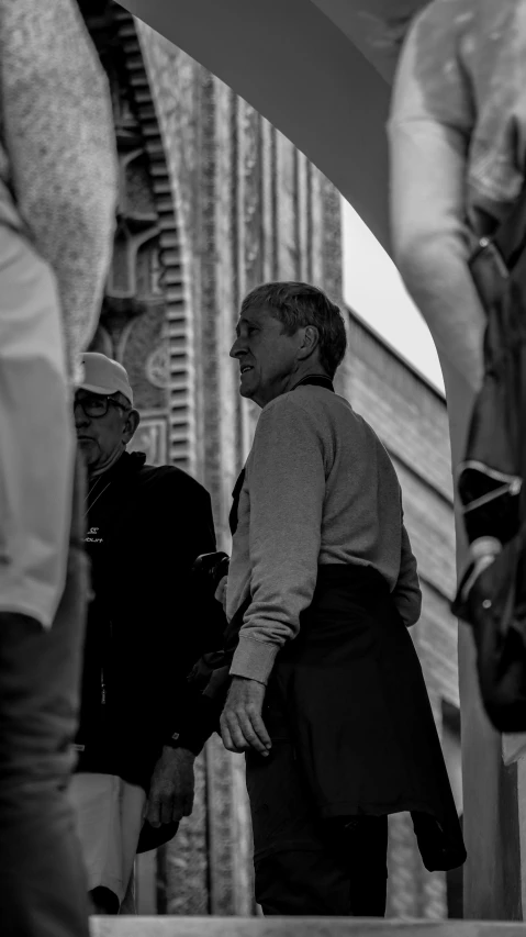 a black and white photo of a group of people, by Giovanni Pelliccioli, pexels contest winner, realism, gray haired, looking around a corner, tourist, philosopher alvin plantinga