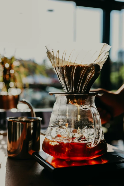 a glass coffee pot with water on top of a table