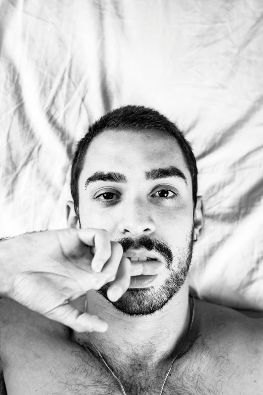 a black and white image of a man on top of bed